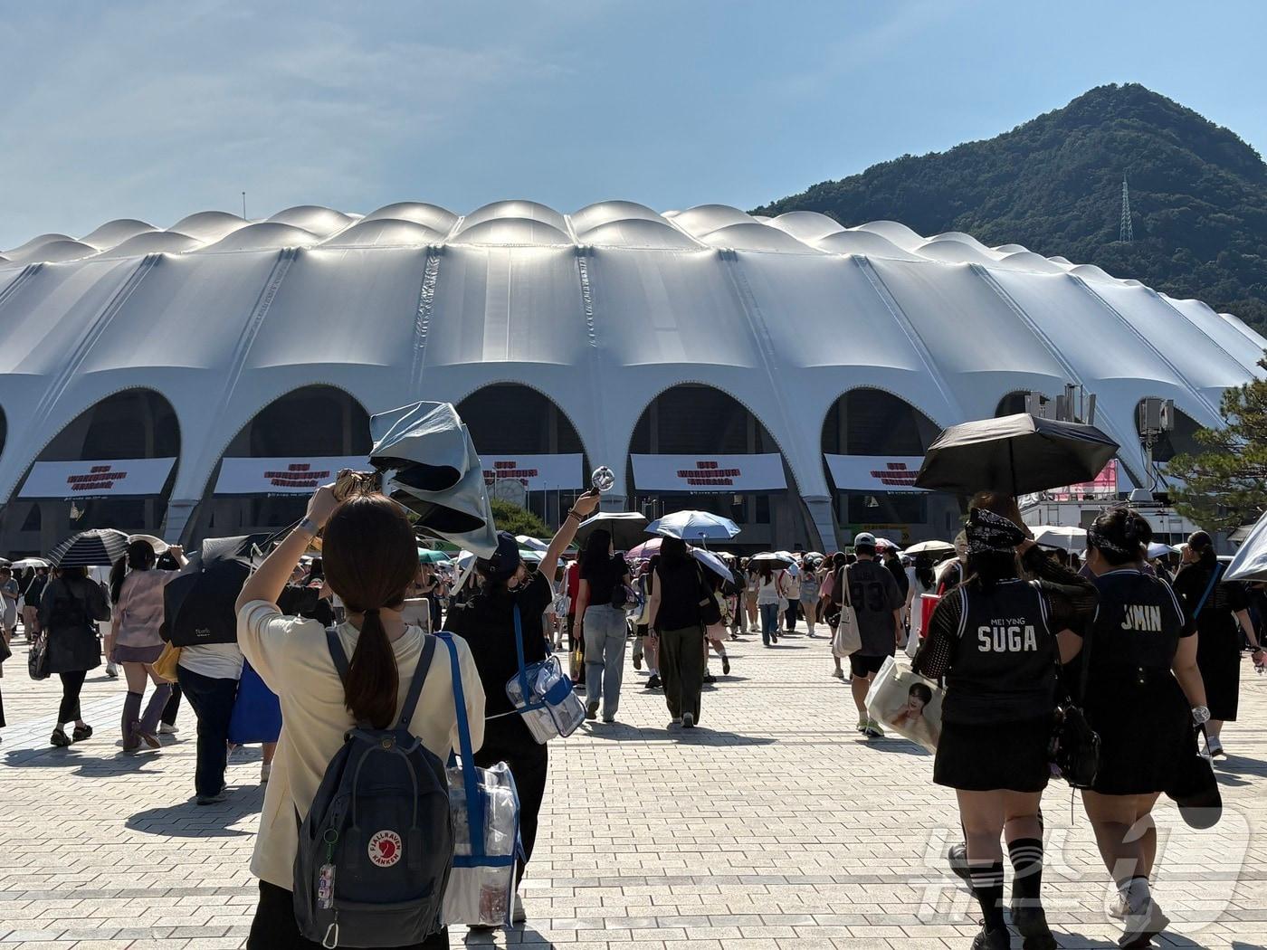 본문 이미지 - 방탄소년단(BTS)의 'BTS 월드 투어 아리랑 IN 부산' 콘서트 마지막 날인 13일 공연이 열리는 부산 아시아드주경기장 입구에서 아미(BTS 팬덤)들이 이동하거나 기념 사진을 촬영하고 있다. ⓒ 뉴스1 박서현 기자