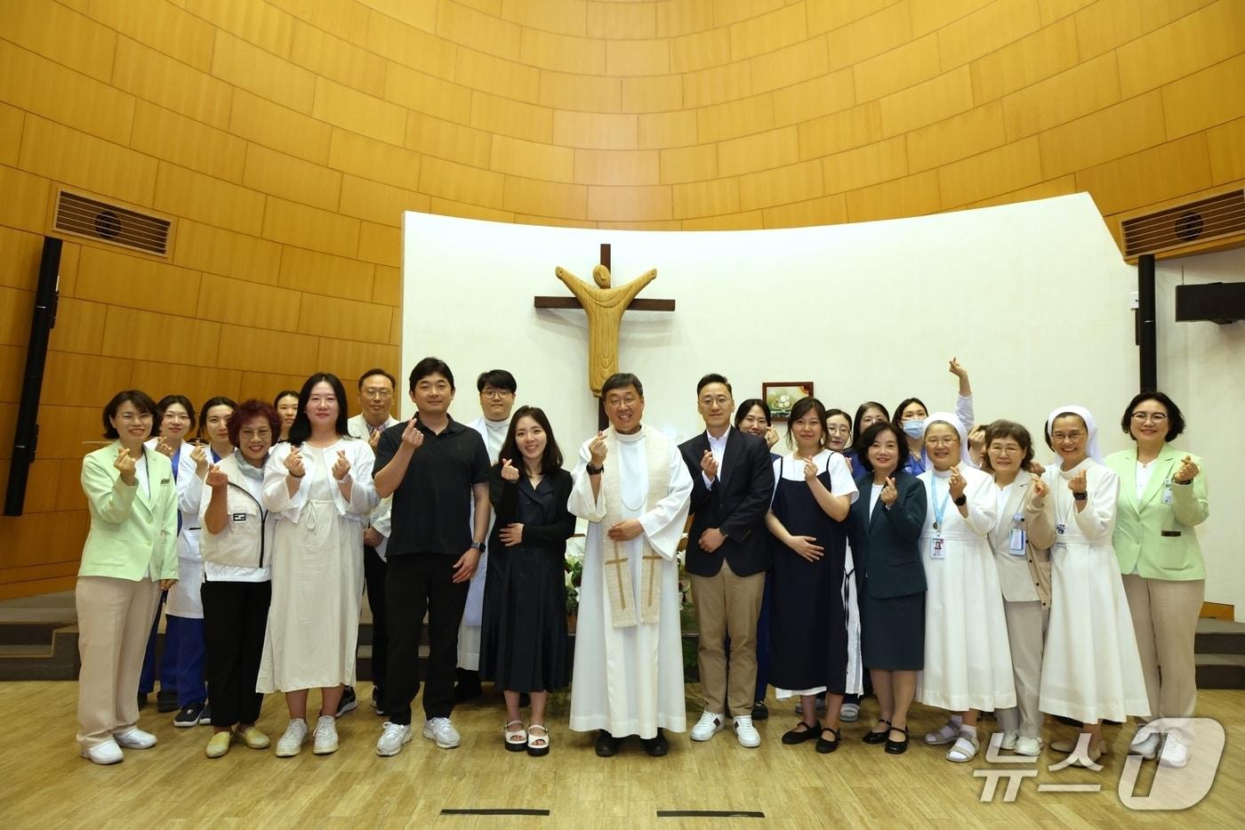본문 이미지 - 나프로 임신부부·태아 축복식을 마친 후 신희준 영성부원장 신부, 박인양 나프로임신센터장 등 의료진과 임신부부들이 함께 기념 촬영을 하고 있다.(가톨릭대 서울성모병원 제공)