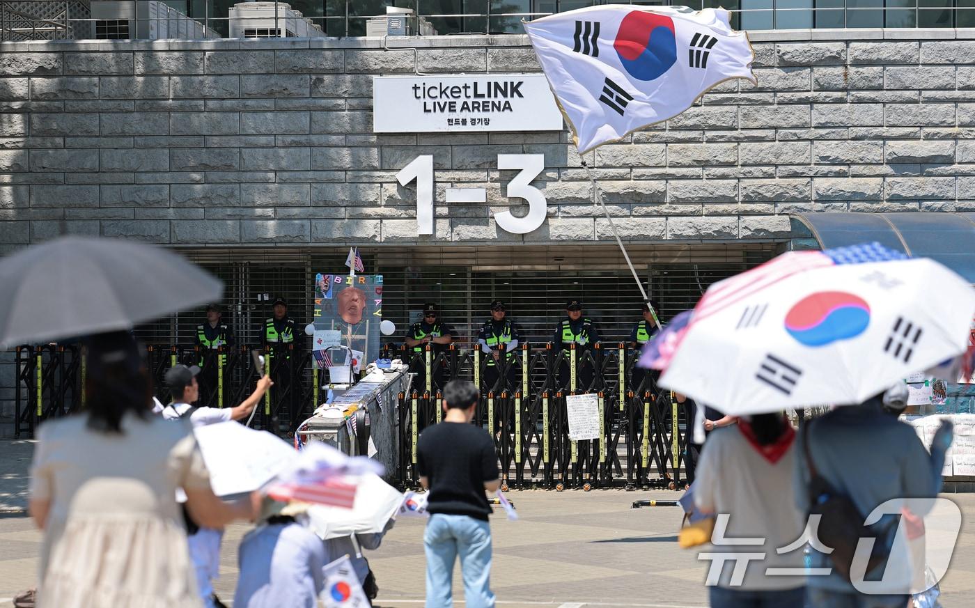 본문 이미지 - 제9회 전국동시지방선거 투표용지 부족 사태를 규탄하는 개표소 봉쇄 시위가 11일째 이어진 15일 서울 송파구 올림픽공원 핸드볼경기장 앞에서 참가자들이 태극기를 흔들며 '부정선거 재선거' 구호를 외치고 있다. 2026.6.15 ⓒ 뉴스1 오대일 기자