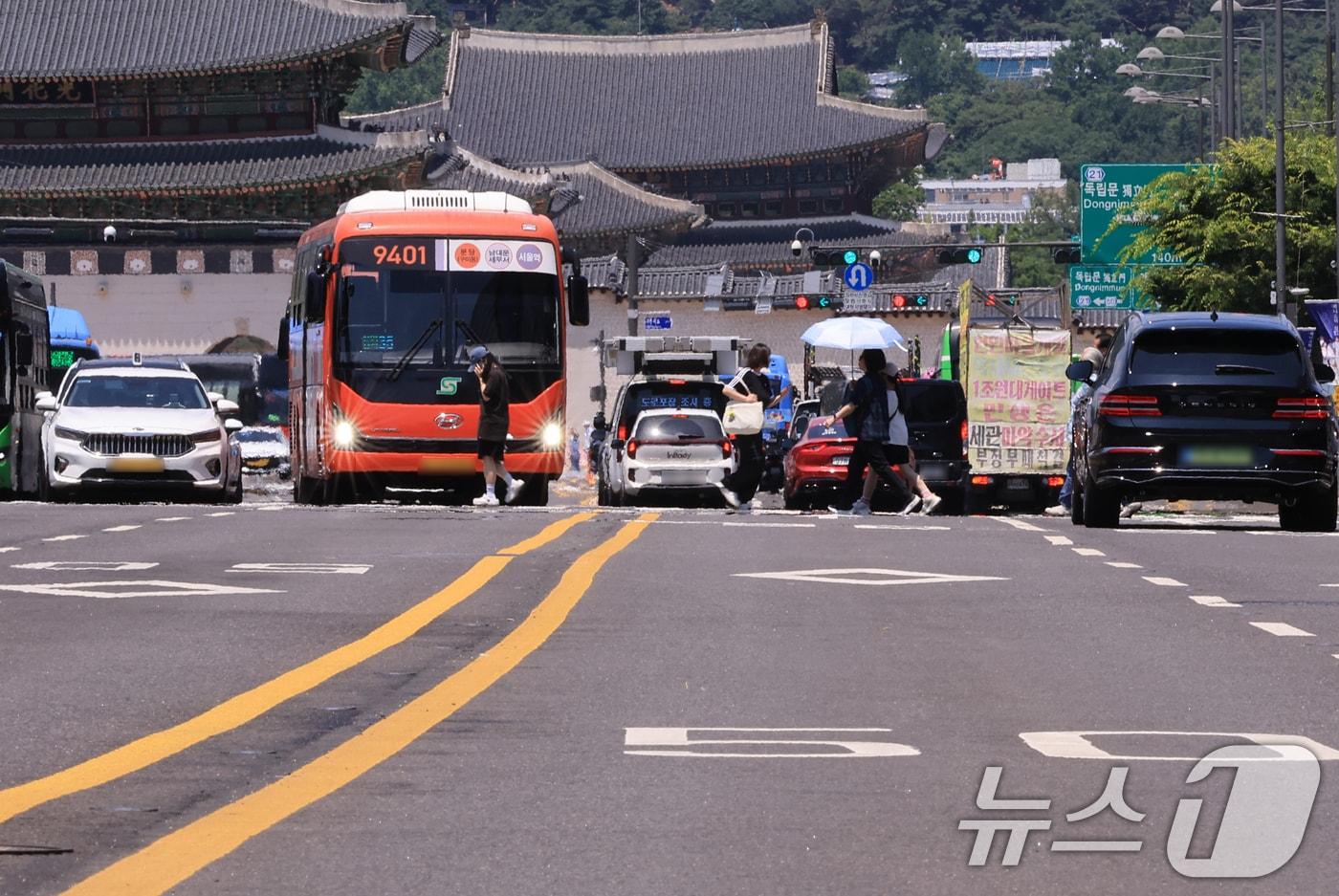 본문 이미지 - 서울 낮 최고기온이 32도까지 오르며 무더운 날씨를 보인 15일 서울 종로구 광화문광장에서 시민들이 길을 건너고 있다. 2026.6.15 ⓒ 뉴스1 이호윤 기자