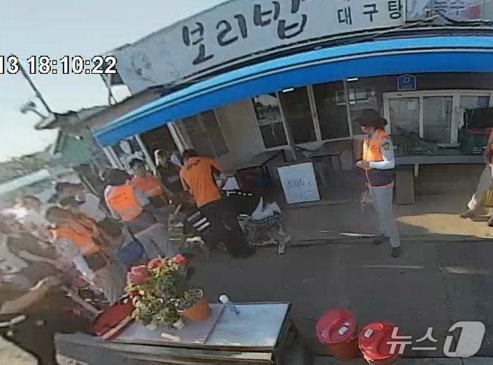 본문 이미지 - 119 구급대원들이 지난 13일 울주군 서생면 간절곶 특산물대축제 행사장 인근 식당에서 쓰러진 30대 여성을 구조하고 있다.(울산소방본부 제공. 재판매 및 DB금지)/뉴스1