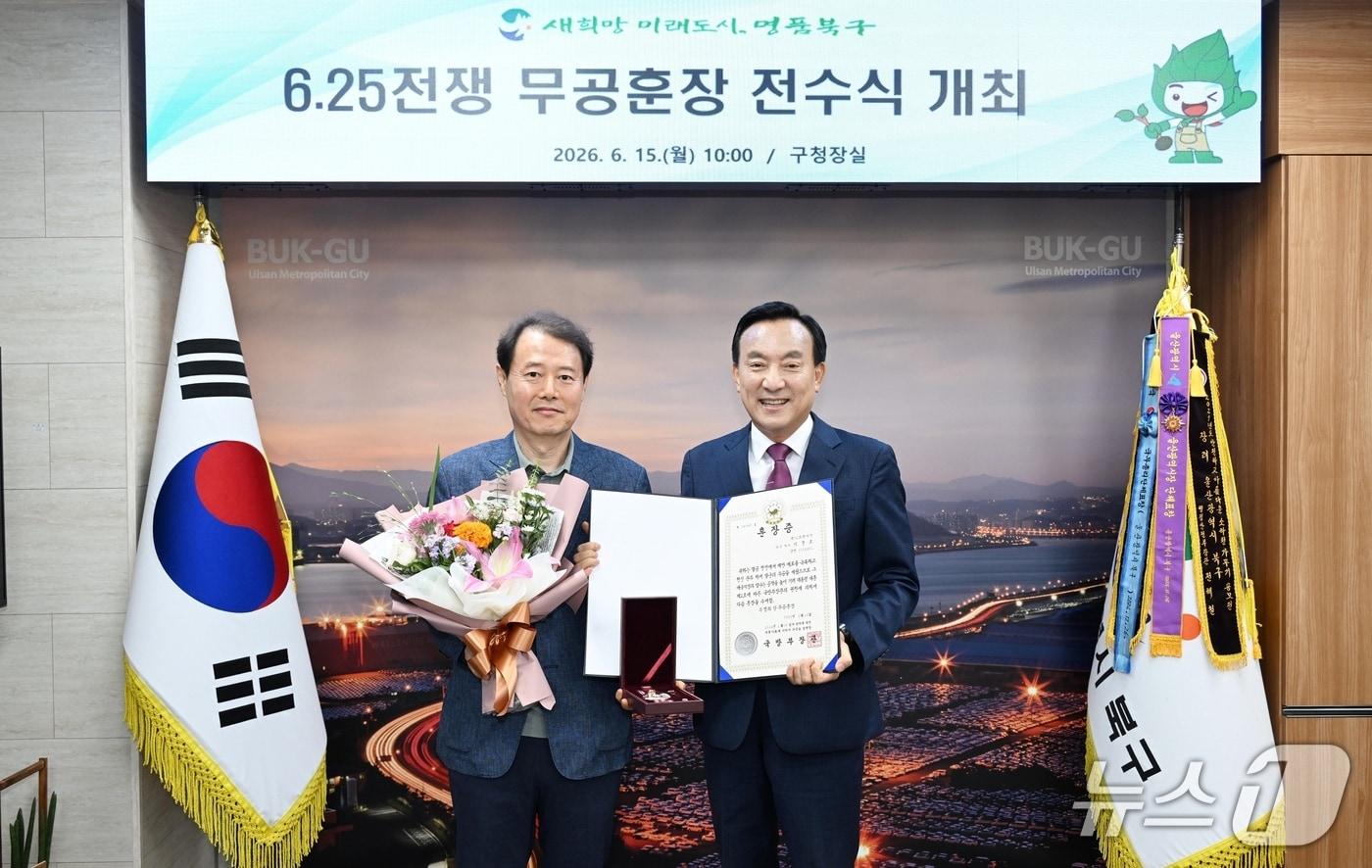 본문 이미지 - 박천동 구청장이 15일 구청장실에서 유공자의 아들 이준동 씨에게 무성화랑 무공훈장과 훈장증을 전달했다.(울산 북구 제공. 재판매 및 DB금지)/뉴스1