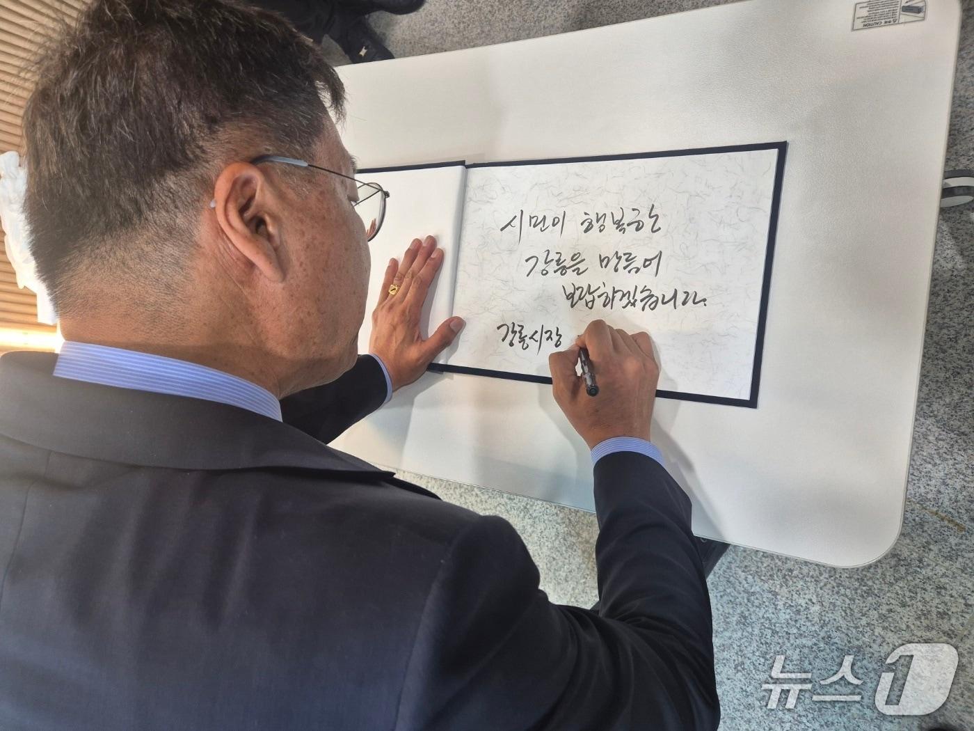 본문 이미지 - 김중남 민선 9기 강원 강릉시장 당선인이 지난 8일 강릉워케이션센터 2층에서 열린 시장직 인수위원회 출범식에서 방명록에 '시민이 행복한 강릉을 만들어 보답하겠습니다'라는 각오를 적고 있다. (뉴스1 DB)