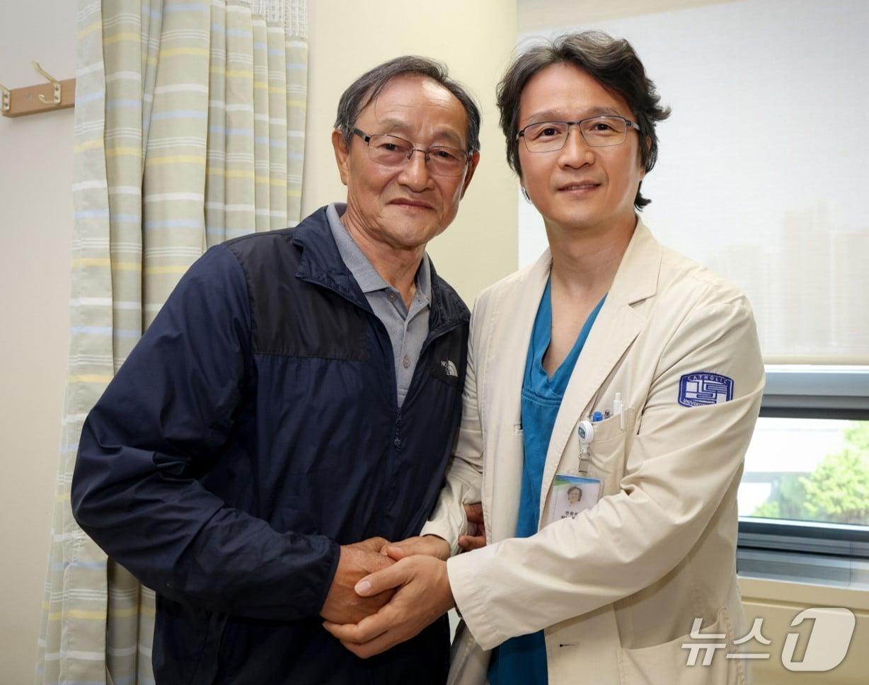 본문 이미지 - 홍성후 가톨릭대 서울성모병원 비뇨의학과 교수가 하대정맥 혈전을 동반한 3기 신장암 고령 환자를 국내 처음으로 후복막 단일공 로봇을 활용해 치료했다. 수술 후 첫 외래를 찾은 환자(좌측)의 건강을 기원하며 기념사진을 촬영했다.(가톨릭대 서울성모병원 제공)