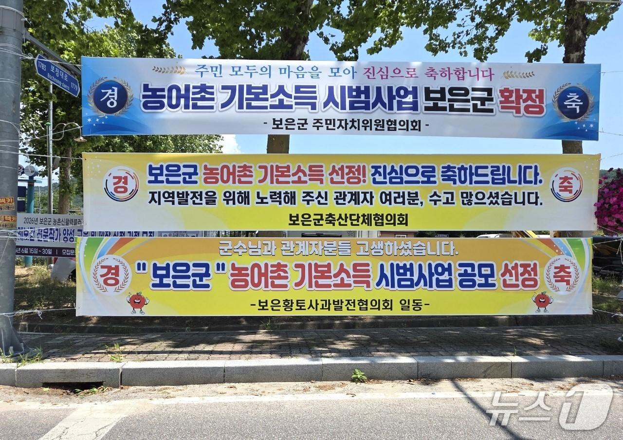 본문 이미지 - 충북 보은군내 곳곳에 농어촌 기본소득 시범사업 추가 선정을 축하하는 현수막이 내걸려 있다.2026.6.16/뉴스1  