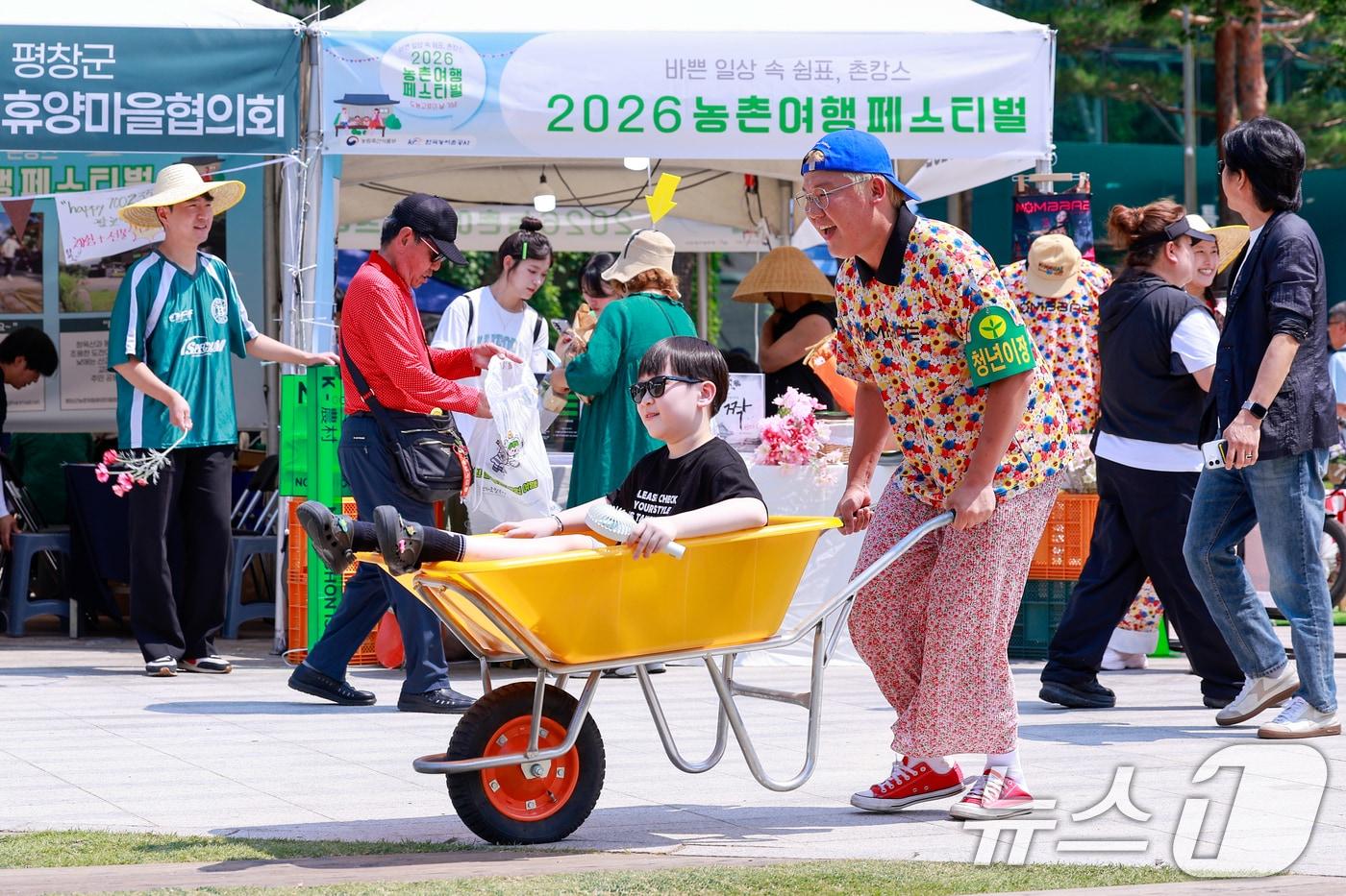 본문 이미지 - 제14회 도농교류의 날을 기념해 16일 중구 서울광장에서 열린 2026 농촌여행 페스티벌에서 홍천 업타운 부스를 찾은 어린이가 외발수레 체험을 하며 즐거운 시간을 보내고 있다. 2026.6.16 ⓒ 뉴스1 안은나 기자