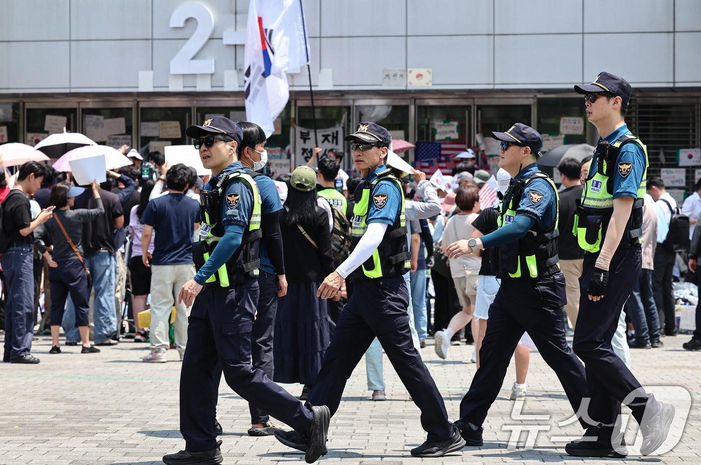 본문 이미지 - 제9회 전국동시지방선거 투표용지 부족 사태를 규탄하는 개표소 봉쇄 시위가 12일째 이어진 16일 서울 송파구 올림픽공원 핸드볼경기장 앞에서 경찰이 이동하고 있다. 2026.6.16 ⓒ 뉴스1 김도우 기자