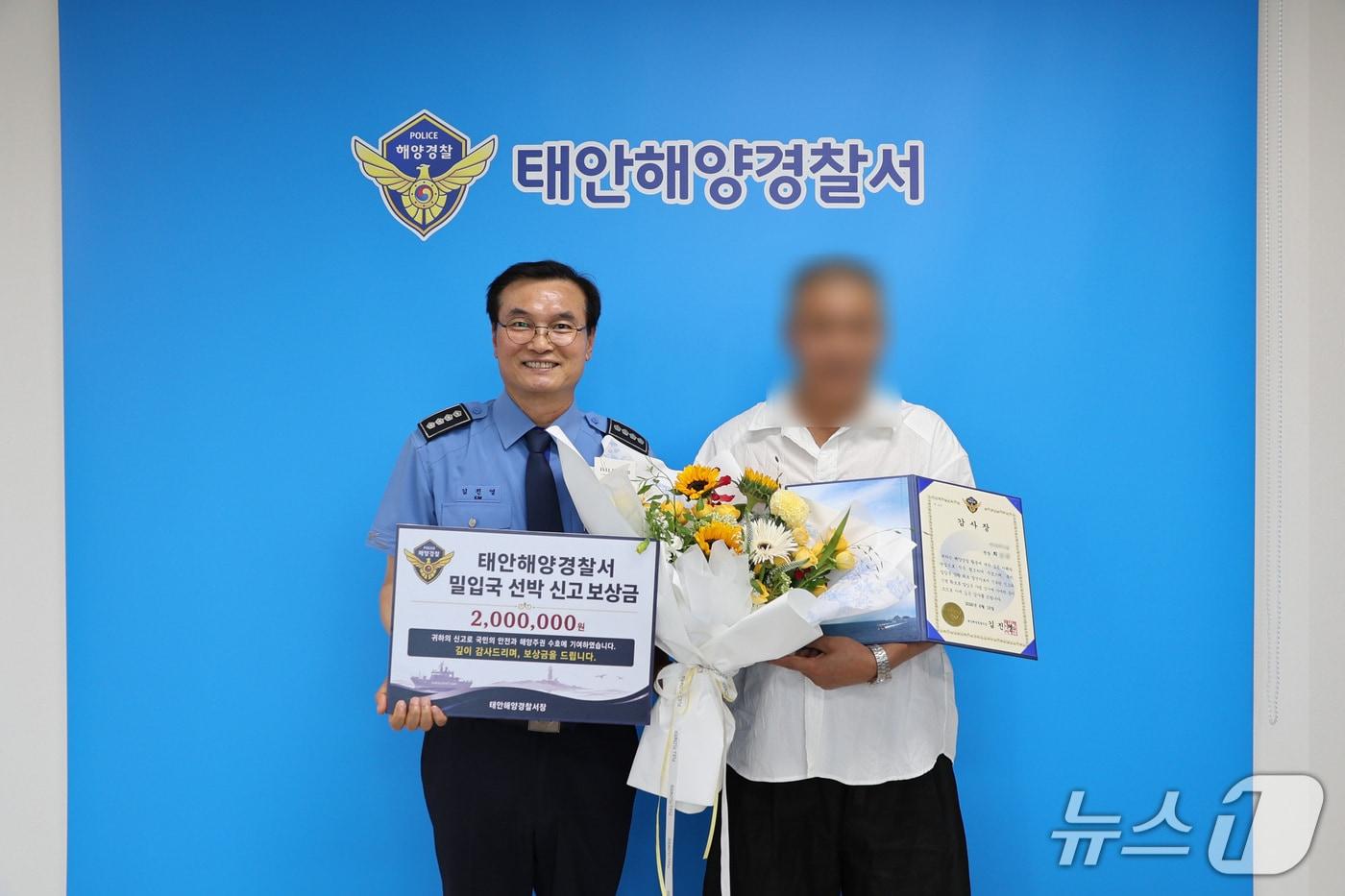 본문 이미지 - 김진영 태안해양경찰서 서장(왼쪽)은 불법 입국을 시도한 중국인 검거에 결정적인 역할을 한 어선 선장에게 보상금을 지급했다.(태안해경 제공. 재판매 및 DB금지)/뉴스1