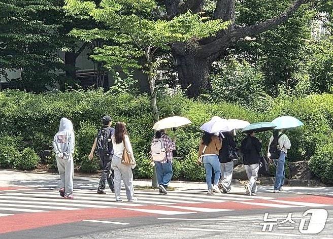 본문 이미지 - 16일 오후 1시 30분께 전북대학교 학생들이 양산을 쓰고 교정을 걷고 있다.2026.6.16/뉴스1 문채연 기자