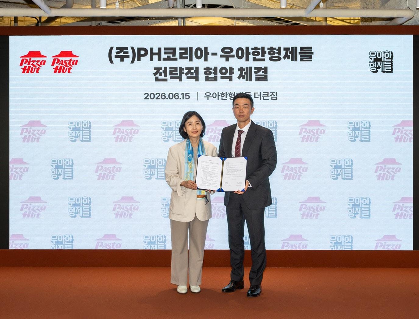 본문 이미지 - 우아한형제들 김지훈 사업부문장(오른쪽)과 PH코리아 김정은 대표가 15일 서울 송파구 우아한형제들 본사에서 전략적 업무 협약(MOU)을 체결한 뒤 기념 촬영을 하고 있다.(우아한형제들 제공)