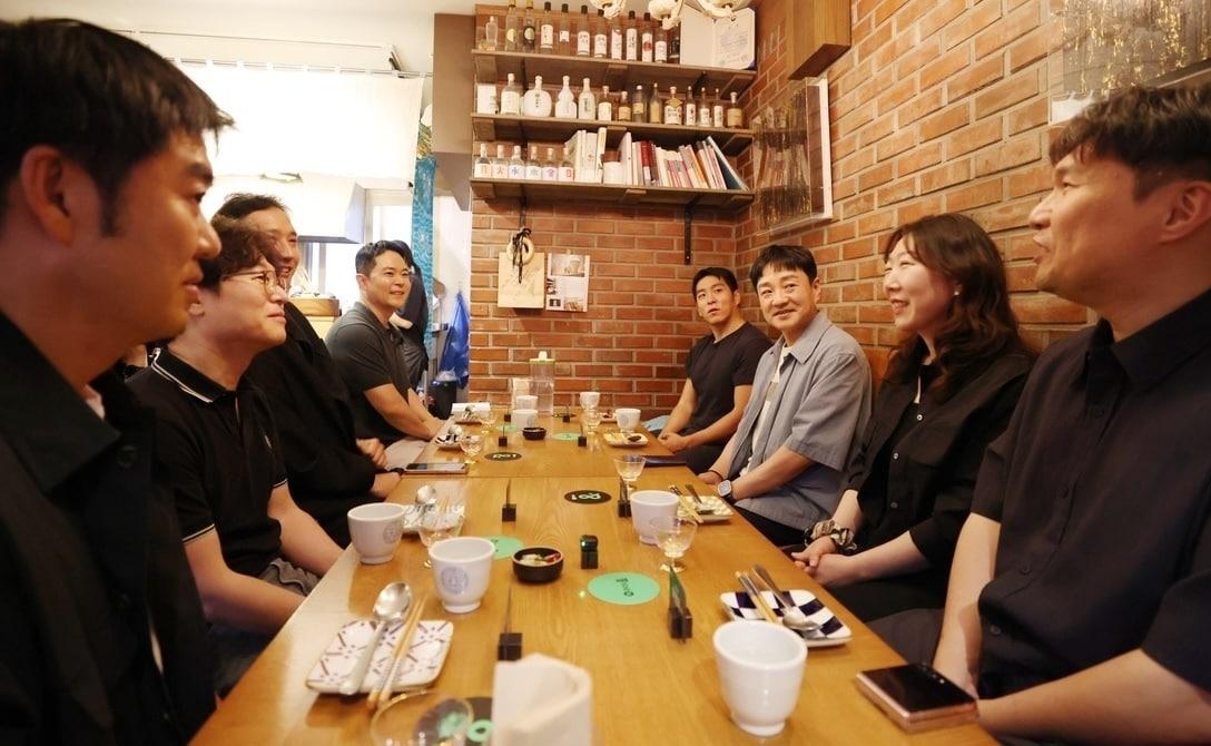 본문 이미지 - 15일 서울 용산구에 위치한 ‘해방촌 윤주당’에서 박상진 네이버페이(Npay) 대표(오른쪽 열 안쪽에서 두번째)가 오프라인 통합 단말기 ‘Npay 커넥트’를 이용 중인 가맹점 대표들과 만나 대화를 나누고 있다.2026.06.15.(네이버페이 제공)