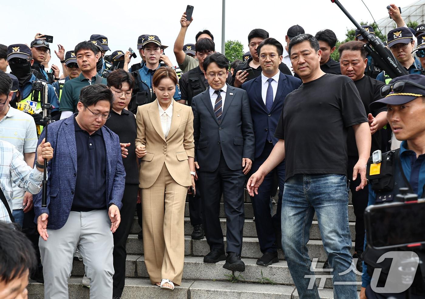 본문 이미지 - 임오경, 전용기, 천준호 더불어민주당 의원이 17일 서울 송파구 올림픽공원 핸드볼경기장 앞에서 투표용지 부족 사태를 규탄하는 시민들에게 항의를 받으며 이동하고 있다. 2026.6.17 ⓒ 뉴스1 김도우 기자