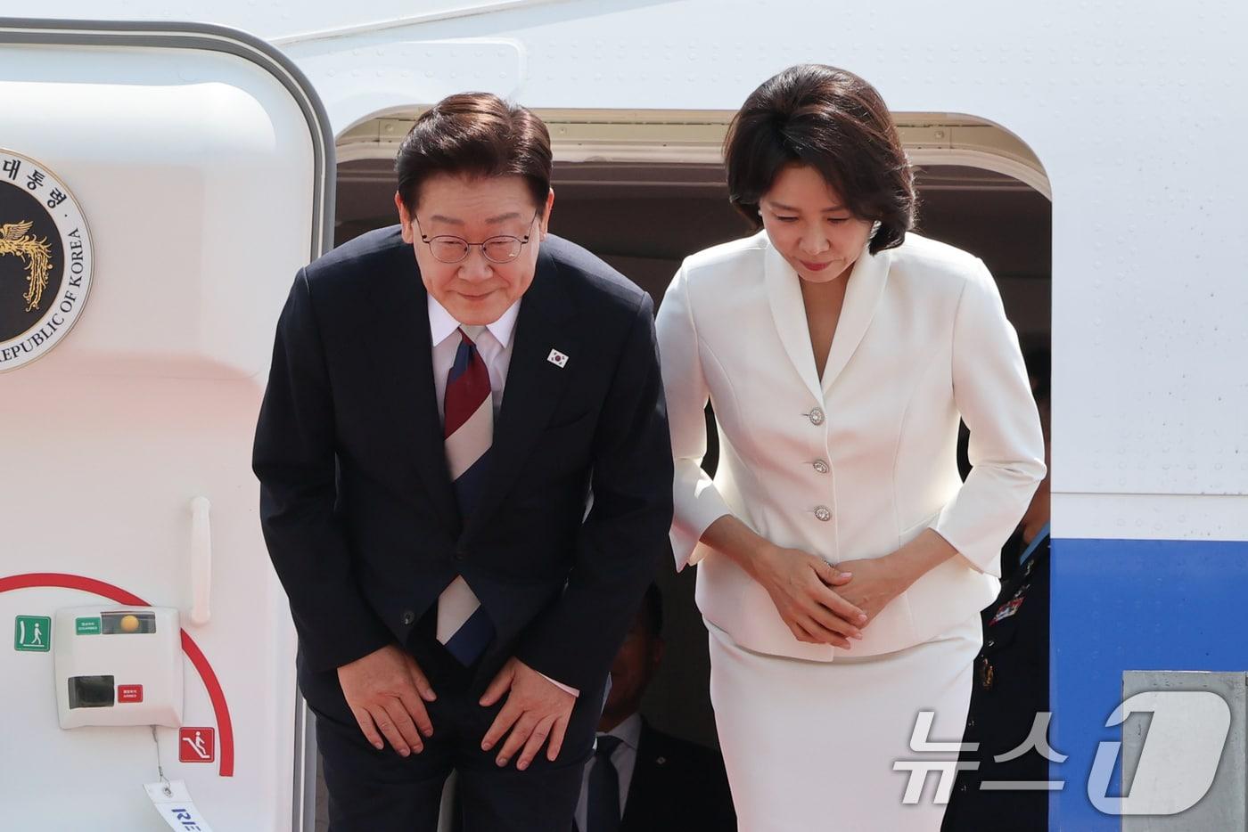 본문 이미지 - 주요 7개국(G7) 정상회의 일정을 마친 이재명 대통령과 김혜경 여사가 18일 경기 성남 서울공항에 도착해 환영객들에게 인사를 하고 있다. 2026.6.18 ⓒ 뉴스1 허경 기자