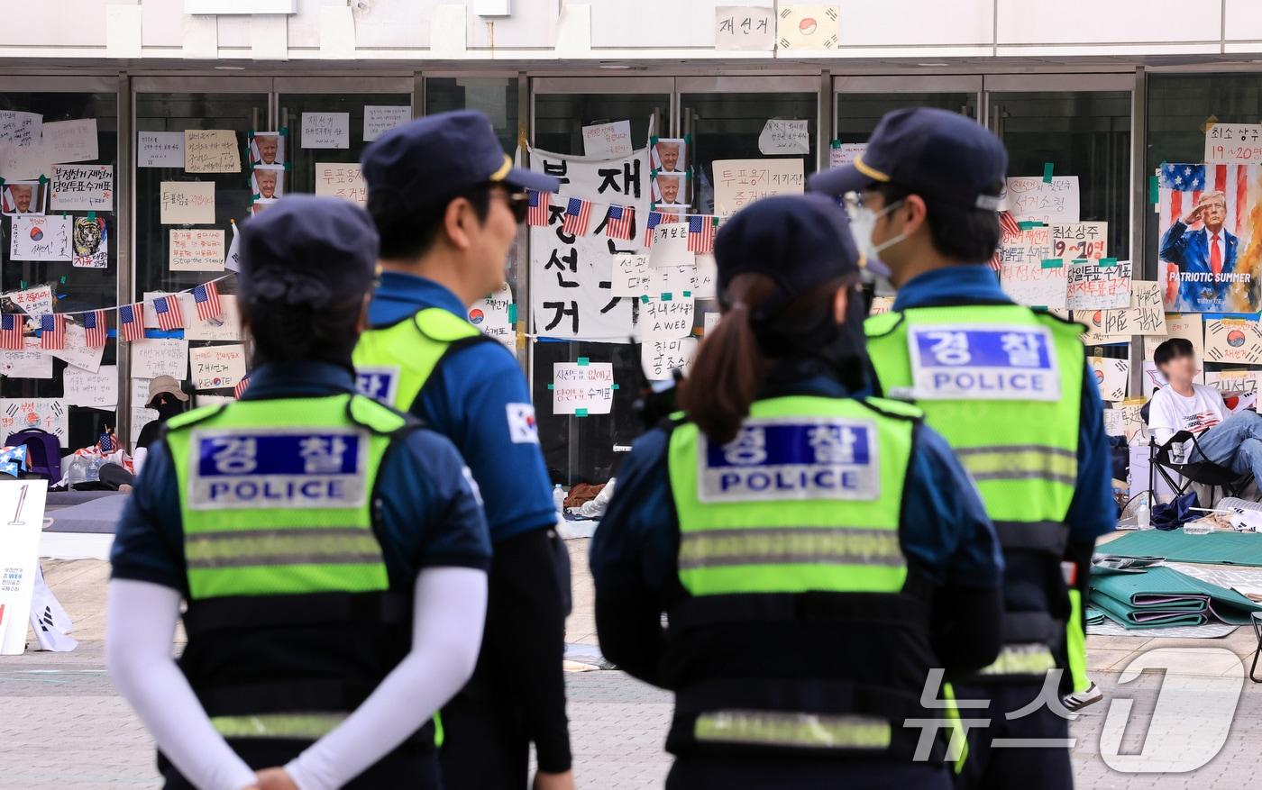 본문 이미지 - 제9회 전국동시지방선거 투표용지 부족 사태를 규탄하는 개표소 봉쇄 시위가 계속된 18일 서울 송파구 올림픽공원 핸드볼경기장 앞에 경찰들이 배치돼 있다. 2026.6.18 ⓒ 뉴스1 이호윤 기자