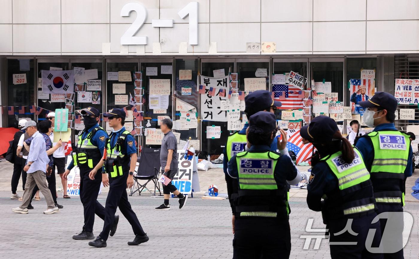 본문 이미지 - 제9회 전국동시지방선거 투표용지 부족 사태를 규탄하는 개표소 봉쇄 시위가 계속된 18일 서울 송파구 올림픽공원 핸드볼경기장 앞에서 경찰들이 이동하고 있다. 2026.6.18 ⓒ 뉴스1 이호윤 기자