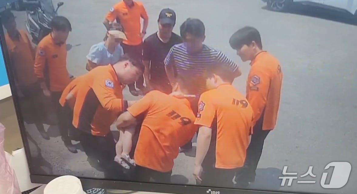 본문 이미지 - 사탕이 목에 걸려 괴로워 하는 꼬마아이  하임리히법 응급처치 하는 구급대원들.(횡성소방서 제공, 재판매 및 DB금지)