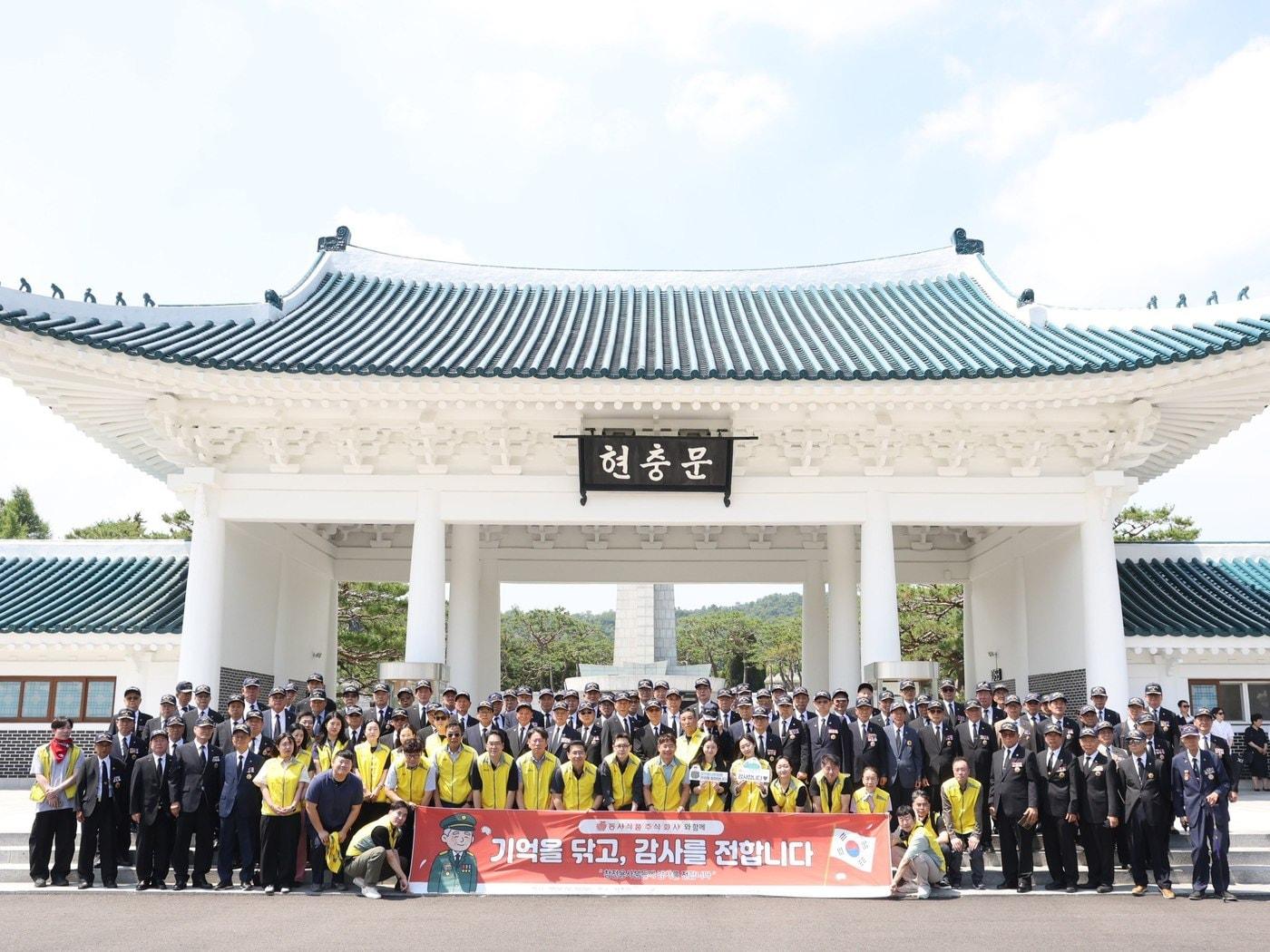 본문 이미지 -  동서식품이 6월 호국보훈의 달을 맞아 지난 18일 국립서울현충원에서 참전용사 초청 오찬 및 묘역 정화 봉사활동을 진행했다. 봉사활동에 참여한 동서식품 직원들과 참전용사들이 기념 촬영을 하고 있다.(동서식품 제공)