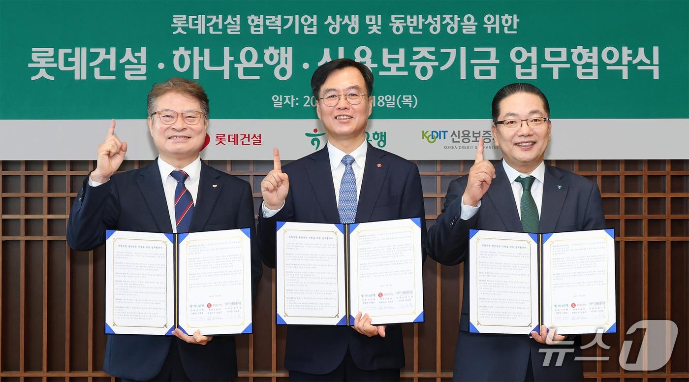 본문 이미지 - 하나은행은 지난 18일 을지로 본점에서 롯데건설, 신용보증기금과 함께 ‘롯데건설 협력기업 상생 및 동반성장을 위한 금융지원 업무협약’을 체결했다. 이날 협약식에 참석한 이호성 하나은행장(사진 오른쪽)이 오일근 롯데건설 대표이사(사진 가운데), 강승준 신용보증기금 이사장(사진 왼쪽)과 함께 업무 협약서를 들고 기념촬영을 하고 있다. 2026.06.18 / 사진제공=하나은행