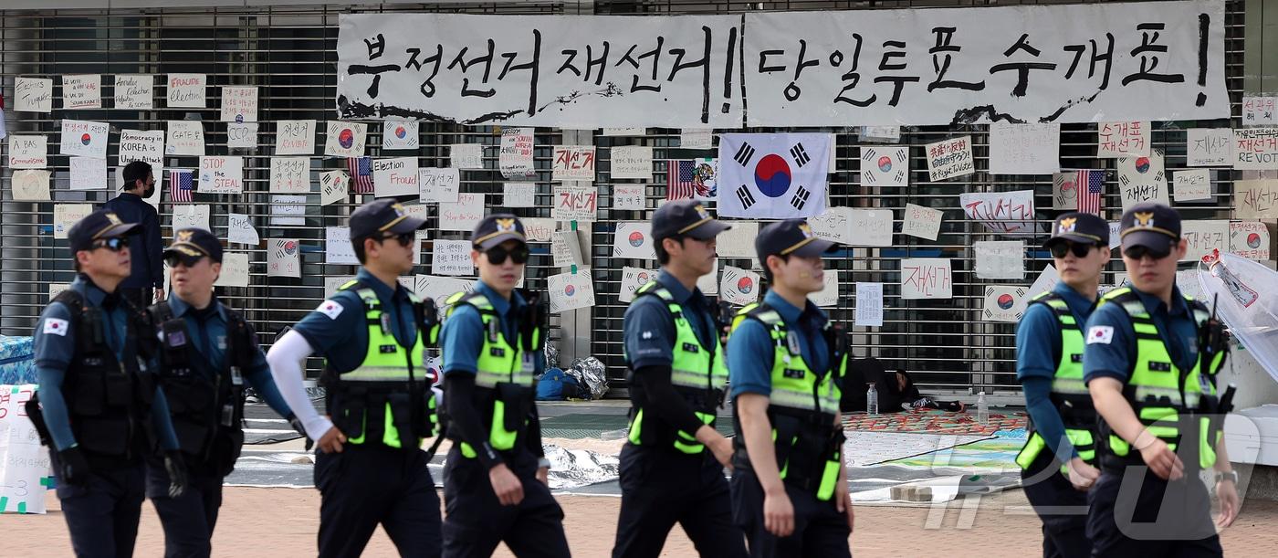 본문 이미지 - 제9회 전국동시지방선거 투표용지 부족 사태를 규탄하는 개표소 봉쇄 시위가 계속된 19일 오전 서울 송파구 올림픽공원 핸드볼경기장 앞에 경찰들이 이동하고 있다. 2026.6.19 ⓒ 뉴스1 김진환 기자