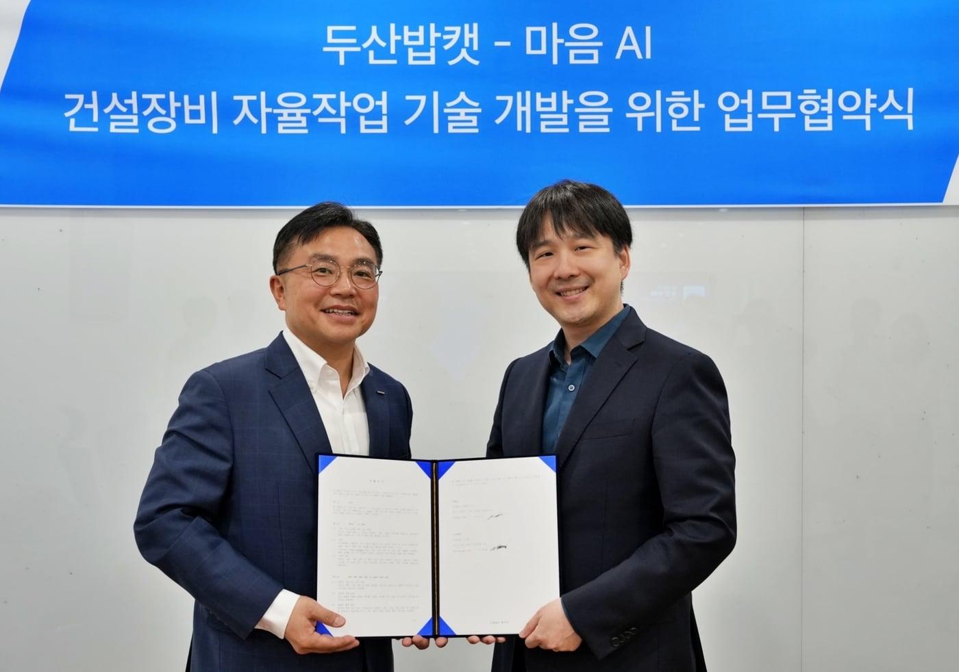 본문 이미지 - 박현철 두산밥캣 부사장(왼쪽)과 최홍섭 마음AI 대표가 2일 경기도 성남시 분당두산타워에서 열린 양해각서 체결식에서 기념 촬영을 하고 있다.(두산밥캣 제공)/뉴스1