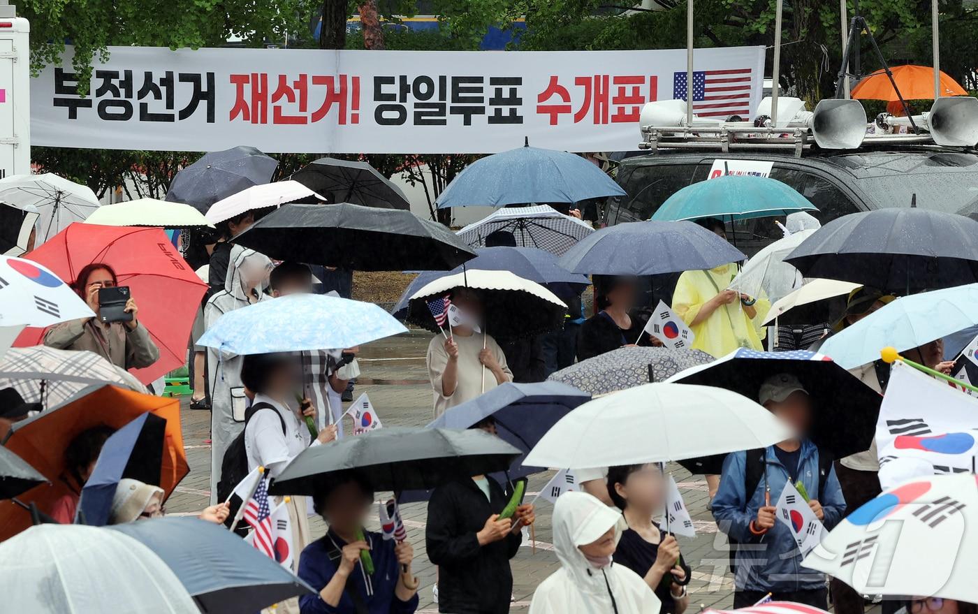 본문 이미지 - 제9회 전국동시지방선거 투표용지 부족 사태를 규탄하는 개표소 봉쇄 시위가 계속된 20일 오전 서울 송파구 올림픽공원 핸드볼경기장 앞에서 시민들이 구호를 외치고 있다. 2026.6.20 ⓒ 뉴스1 김진환 기자