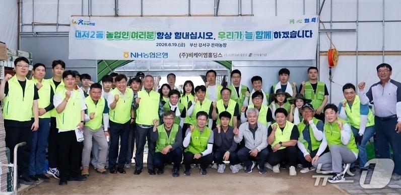 본문 이미지 - 19일 부산 강서구 대저2동 오이농가에서 NH농협은행 및 비케이엠홀딩스 임직원들이 일손돕기를 실시하고 기념촬영을 하고 있다. NH농협은행 제공.