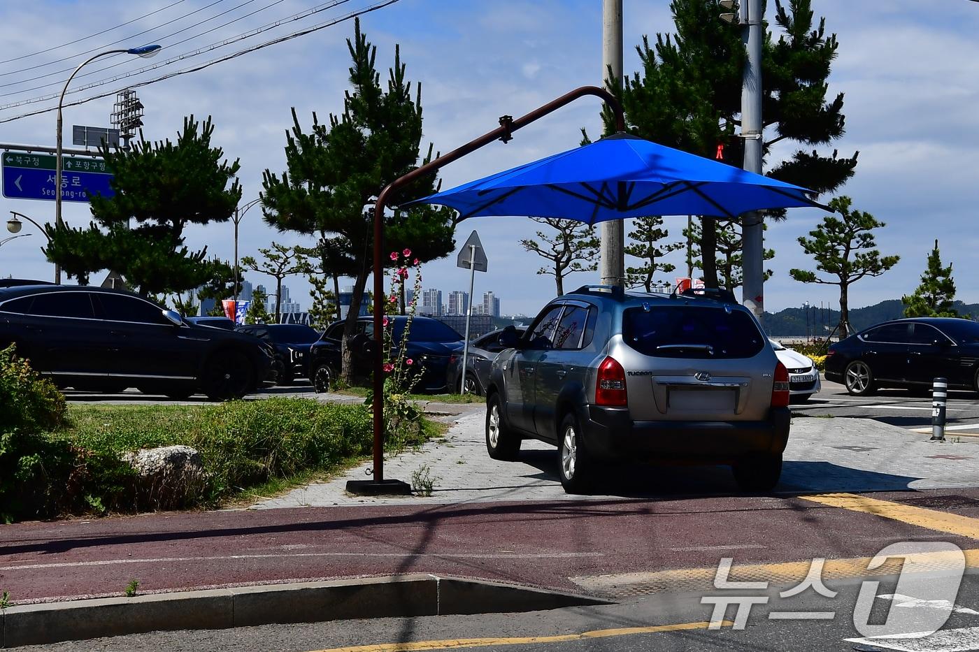 본문 이미지 - 21일 오후 경북 포항시 송도해수욕장 횡단보도 그늘막 밑에 불법 주차한 SUV 차량  ⓒ 뉴스1 최창호 기자