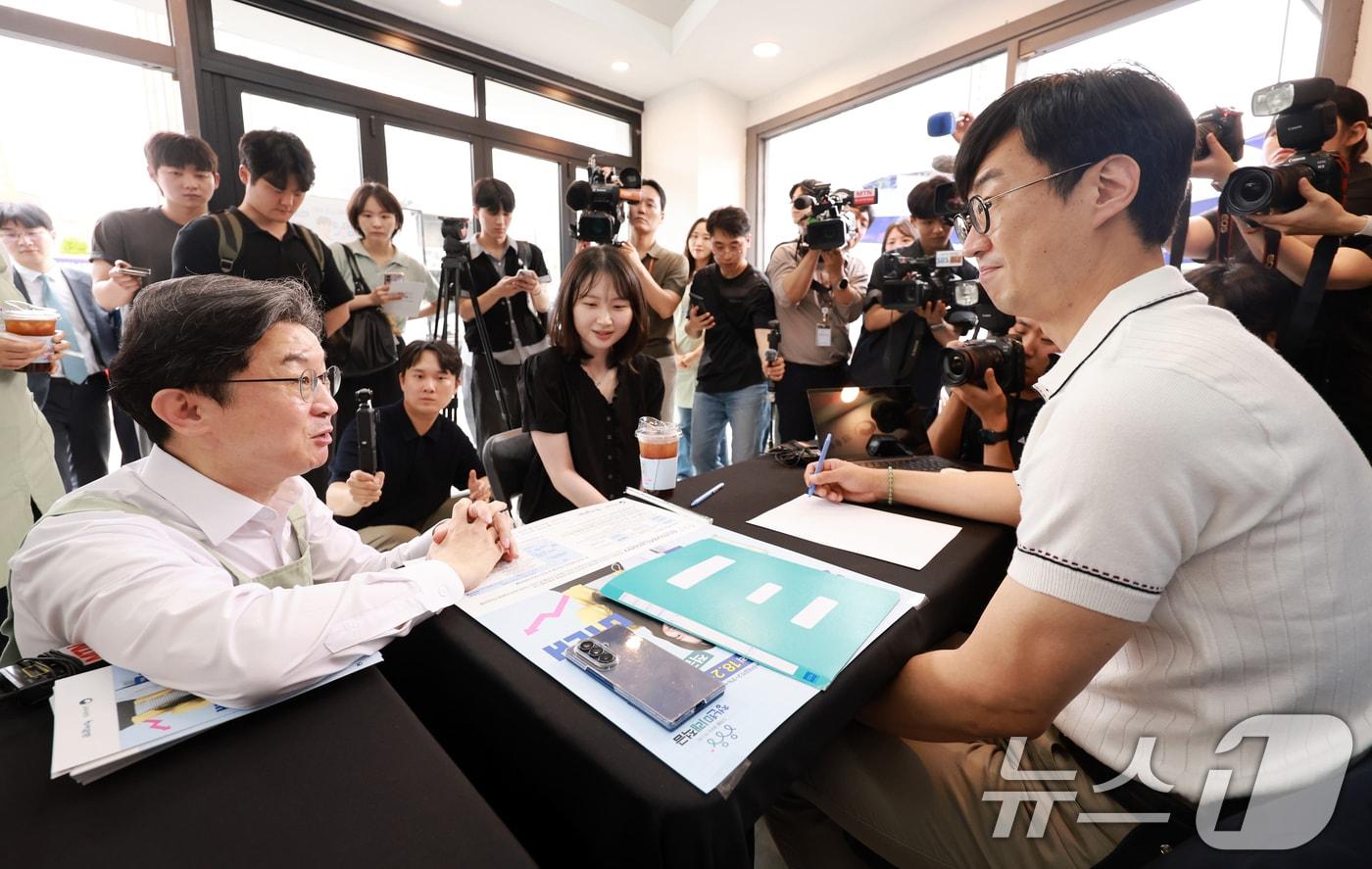 본문 이미지 - 이억원 금융위원장이 '청년미래적금' 가입 신청이 시작된 22일 서울 성동구 신한빌딩에서 상담받는 청년들과 대화를 나누고 있다. 2026.6.22 ⓒ 뉴스1 이호윤 기자