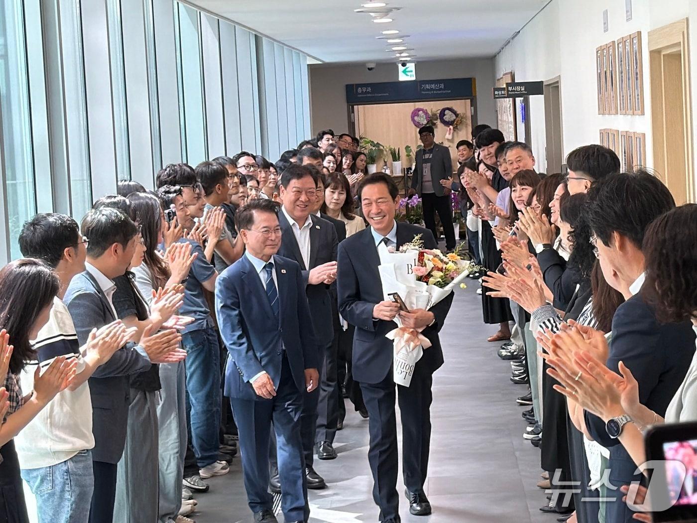 본문 이미지 - 22일 오전 강원 춘천시청 3층 로비에서 우상호 강원특별자치도지사 당선인이 육동한 춘천시장과 직원들의 환대를 받으며 이동하고 있다.2026.6.22 한귀섭 기자 
