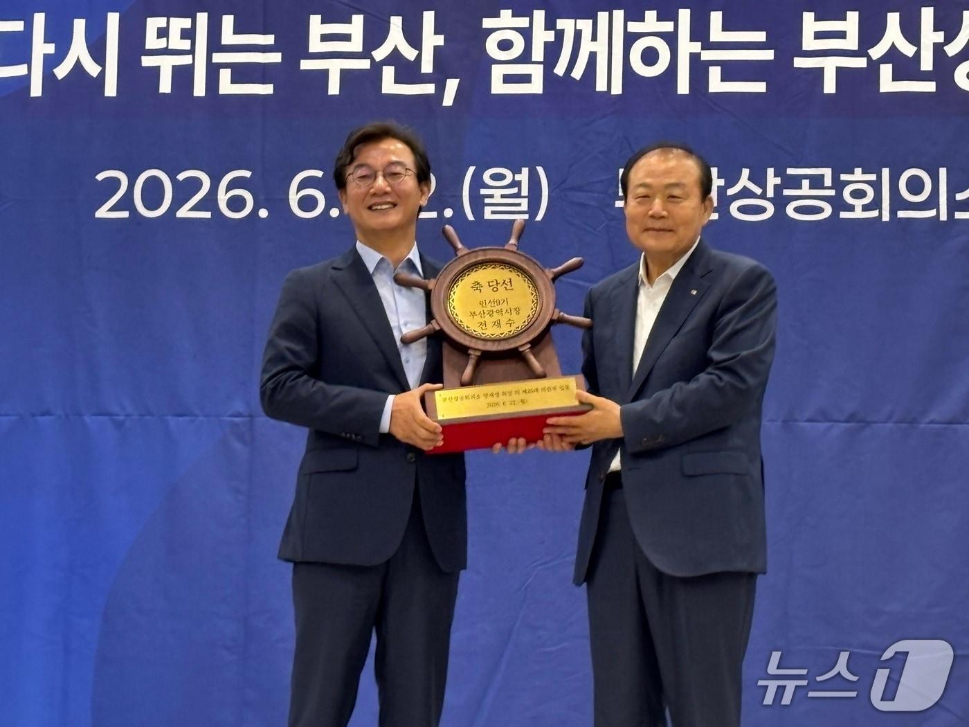 본문 이미지 - 양재생 부산상의 회장이 전재수 부산시장 당선인에 당선축하패를 전달하는 모습 2026.6.22 뉴스1 ⓒ News1 홍윤 기자