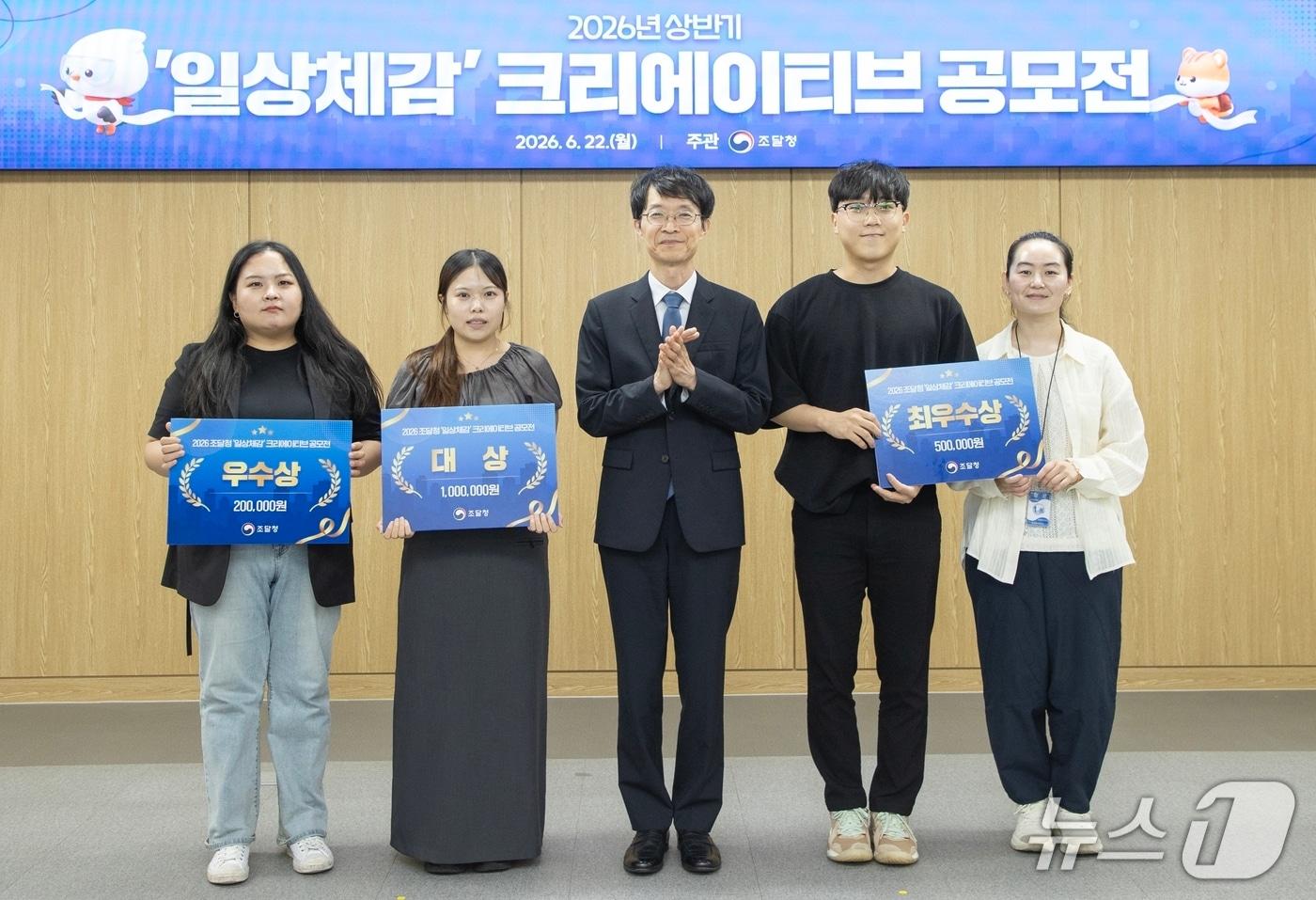 본문 이미지 - 강성민 조달청 차장(가운데)이 22일 정부 대전청사에서 '2026 조달청 일상 체감 크리에이티브 공모전' 시상식을 개최하여 수상자들과 기념촬영을 하고 있다(조달청 제공.재판매 및 DB금지)/뉴스1