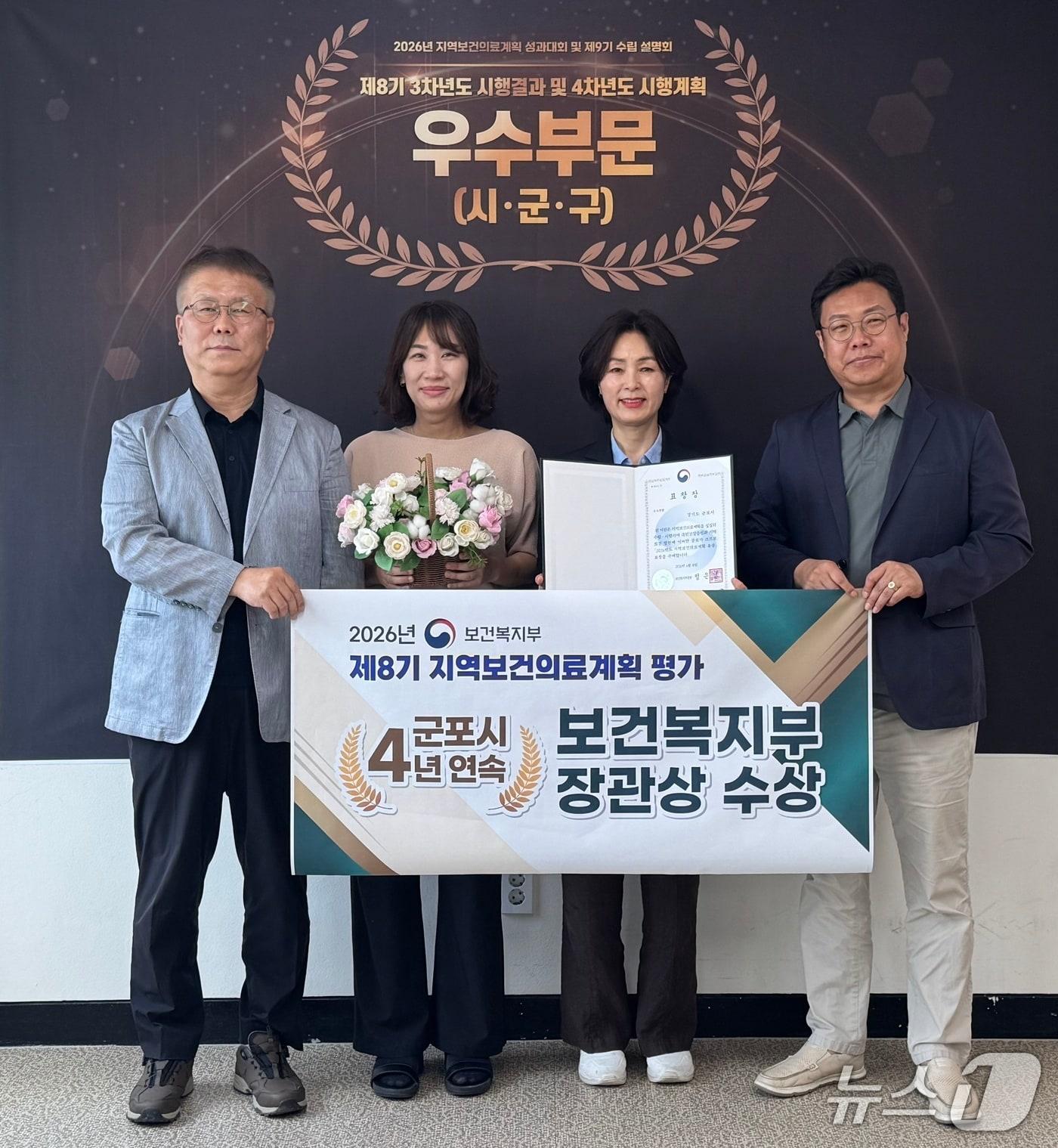 본문 이미지 - 경기 군포시 관계자들이 보건복지부가 실시한 제8기 지역보건의료계획 평가에서 우수 지자체로 선정돼 장관상을 수상해 기념촬영을 하고 있다. (군포시 제공. 재판매 및 DB 금지) 2026.6.22/뉴스1