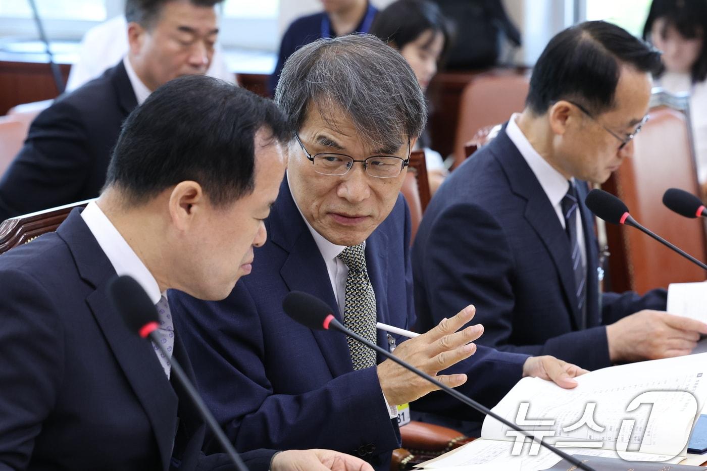본문 이미지 - 노태악 전 중앙선거관리위원장과 위철환 선관위원장 직무대행이 23일 오전 서울 여의도 국회에서 열린 제9회전국동시지방선거투표용지부족 사태 등 국민참정권침해진상규명 및 선거관리개혁을 위한 국정조사 특별위원회에 참석해 대화를 나누고 있다. 2026.6.23 ⓒ 뉴스1 신웅수 기자