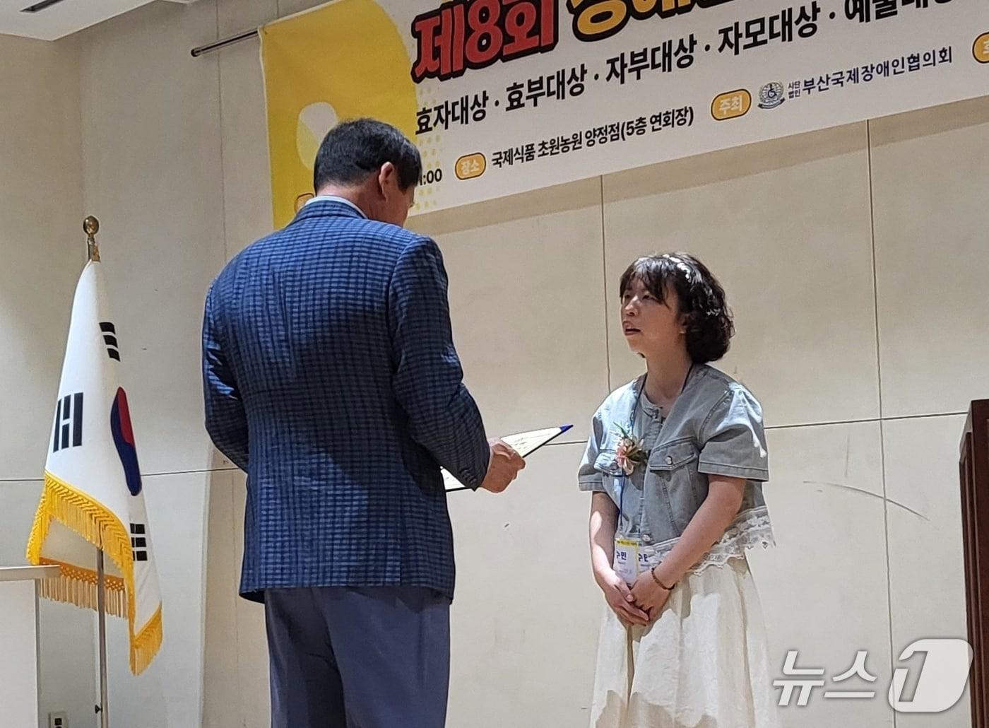 본문 이미지 - 발달장애인 예술가 천수민 씨가 '제8회 장애인가족 사랑나눔 대상'에서 예술대상을 받는 모습 (독자 제공. 재판매 및 DB금지)