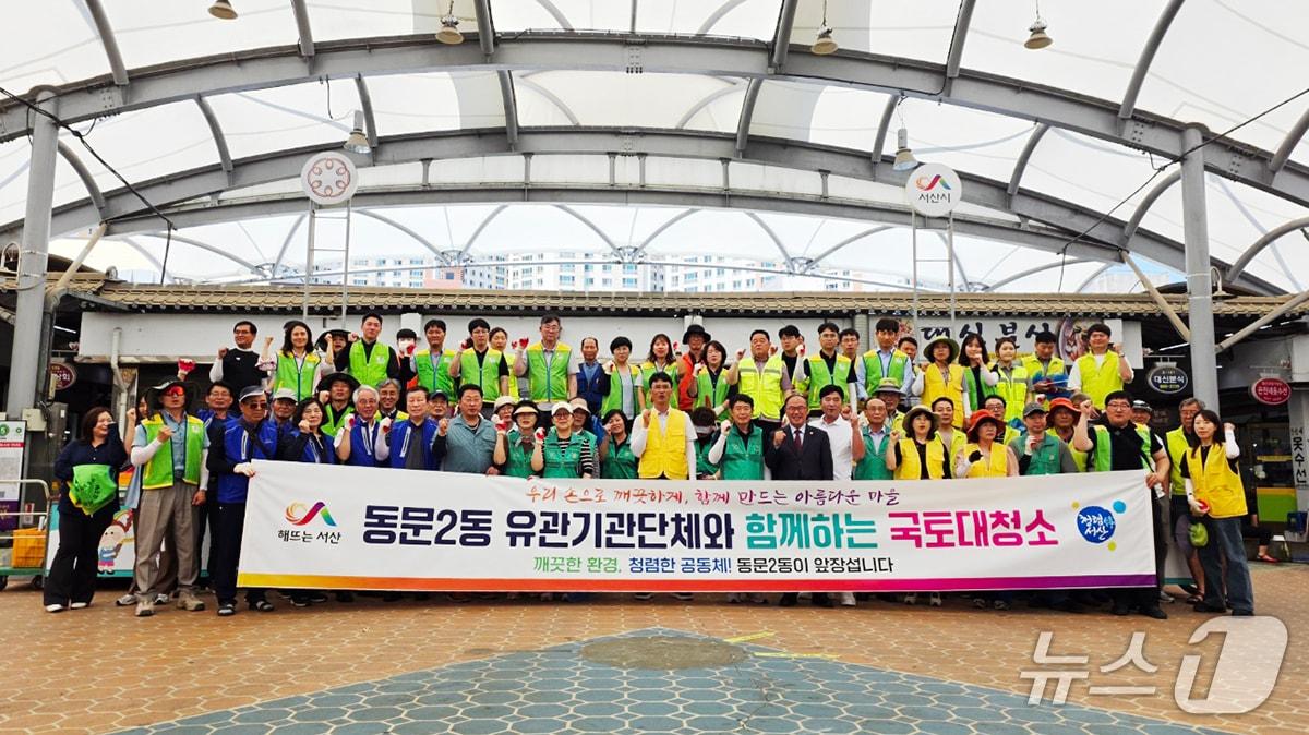 본문 이미지 - 지난 23일 ‘일제 대청소의 날’을 맞아 동부전통시장 일원에서 국토 대청소 운동을 전개하고 기념촬영을 하고 있다.(서산시 제공. 재판매 및 DB금지)/뉴스1