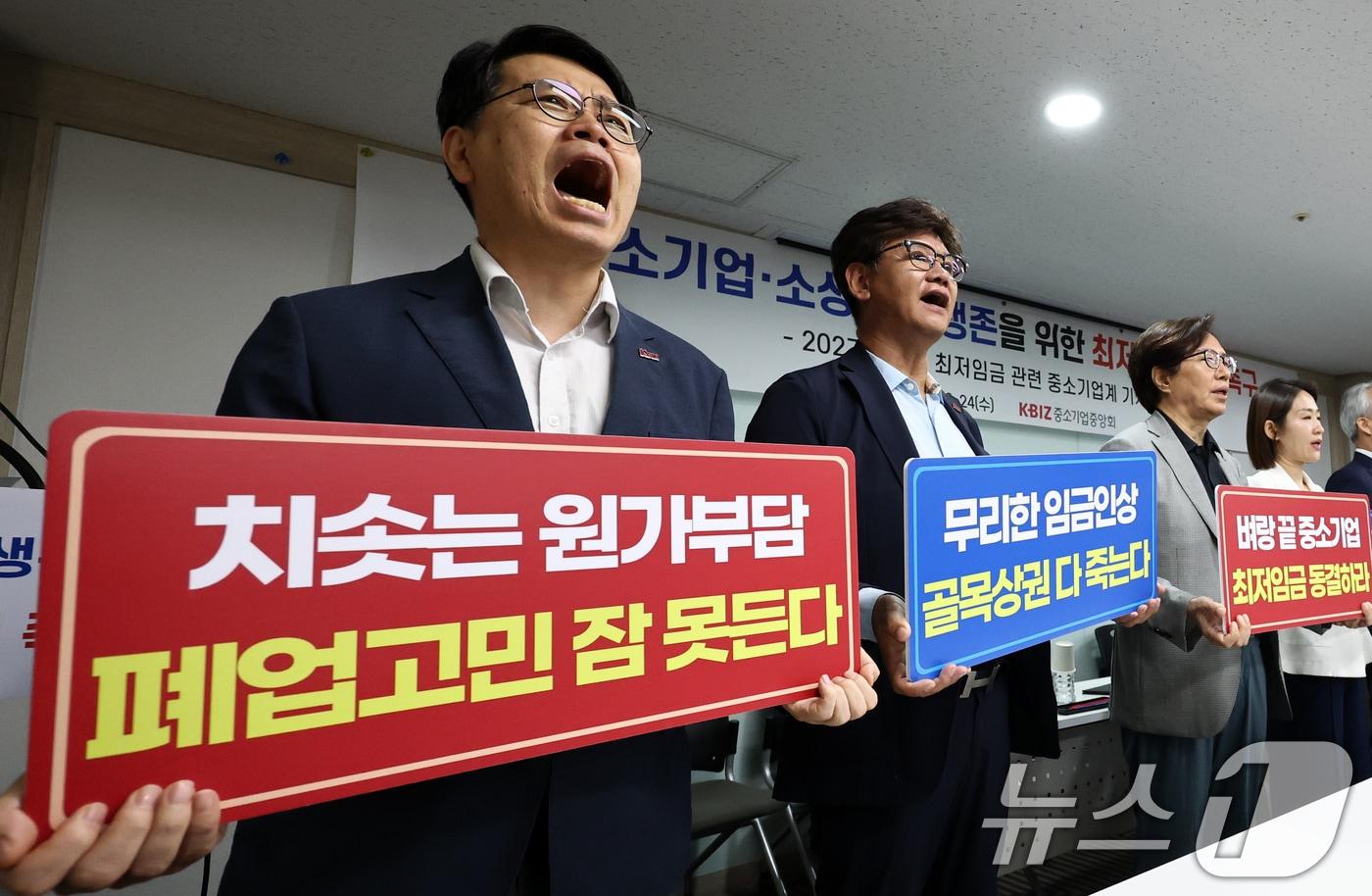 본문 이미지 - 이재광 중소기업중앙회 노동인력위원장을 비롯한 중소기업, 소상공인 대표들이 24일 오전 서울 영등포구 중소기업중앙회에서 열린 중소기업·소상공인 생존을 위한 최저임금 결정 촉구 기자회견에서 구호를 외치고 있다. 왼쪽부터 이중학 GS25 경영주협의회, 곽인학 한국금속패널공업협동조합 이사장, 이재광 중기중앙회 노동인력위원장, 윤영발 한국자동판매기운영협동조합 이사장, 금지선 한국메이크업미용사회 회장, 이기재 한국펫산업연합회, 김현 한국철근가공업협동조합, 양옥석 중소기업중앙회 인력정책본부장. 2026.6.24 ⓒ 뉴스1 최지환 기자