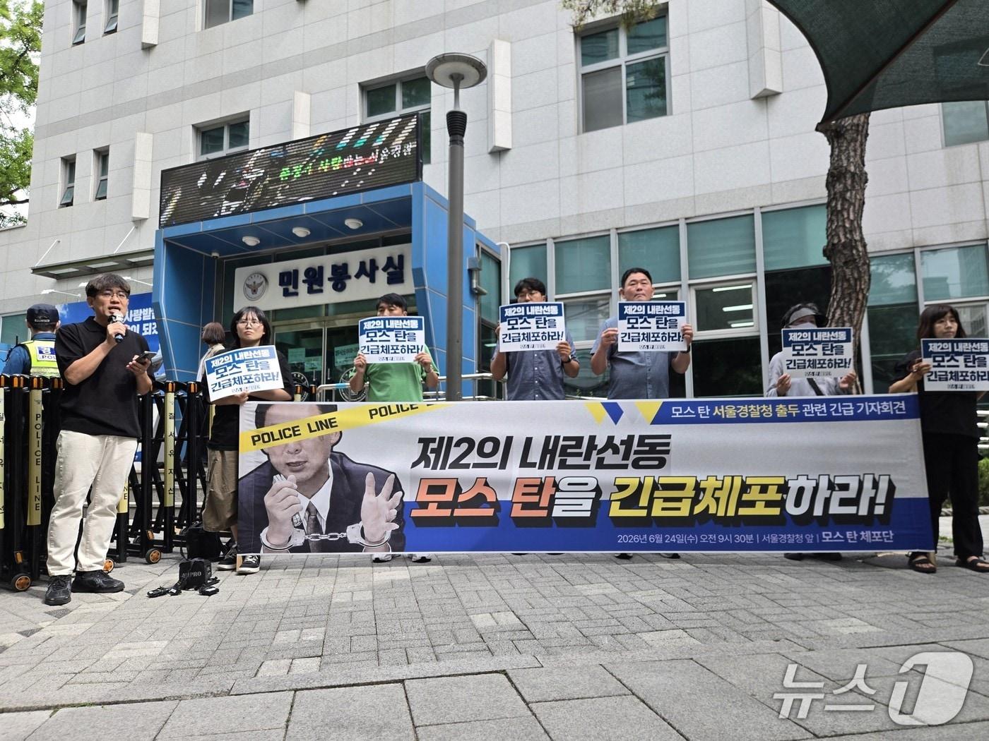 본문 이미지 - 촛불행동 등 시민사회단체로 구성된 '모스 탄 체포단'이 24일 오전 서울경찰청 앞에서 기자회견을 여는 모습. 2026.6.24 ⓒ 뉴스1 김범수 수습기자