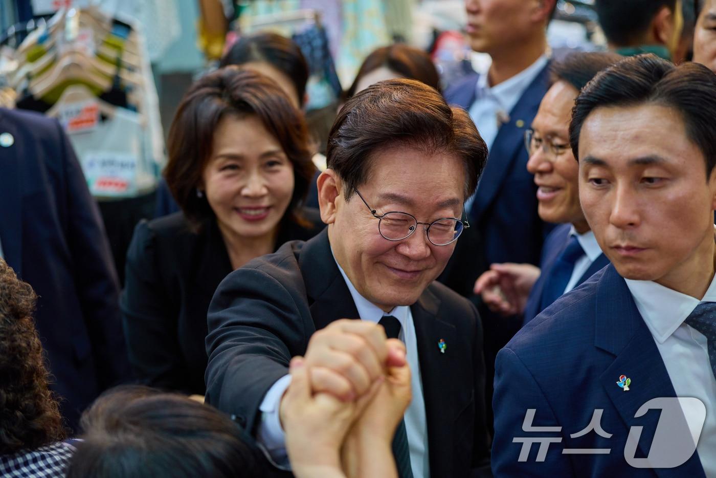 본문 이미지 - 이재명 대통령과 김혜경 여사가 25일 경기 수원시 팔달문시장을 찾아 상인들과 인사하고 있다. (청와대 제공. 재판매 및 DB 금지) 2026.6.25 ⓒ 뉴스1 허경 기자