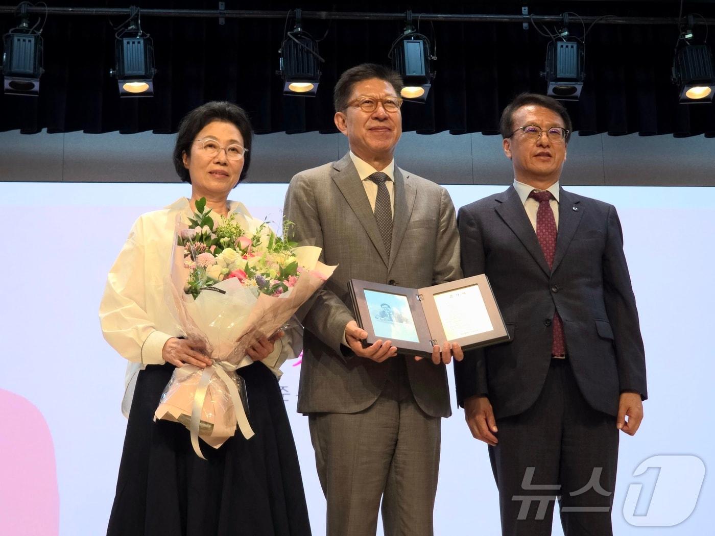 본문 이미지 - 박형준 부산시장이 26일 부산시청 1층 대강당에서 열린 시장 퇴임식에서 조현 여사와 함께 감사패를 받은 후 기념촬영을 하고 있다. 2026.6.26 ⓒ 뉴스1 이주현 기자