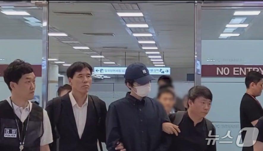 본문 이미지 - 경북경찰청 직원들이 만화 불법 복제 웹사이트 '마나토끼' 운영자 A 씨를 국내로 송환하고 있다.(경북경찰청 제공, 재판매 및 DB 금지)