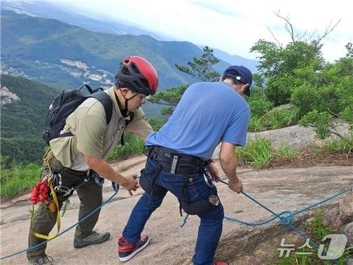 본문 이미지 - 지난 27일 북한산 염초봉 직벽에 고립된 외국인이 출동한 국립공원구조대에 의해 구조되고 있는 모습. (북한산국립공원사무소 제공, 재판매 및 DB금지)