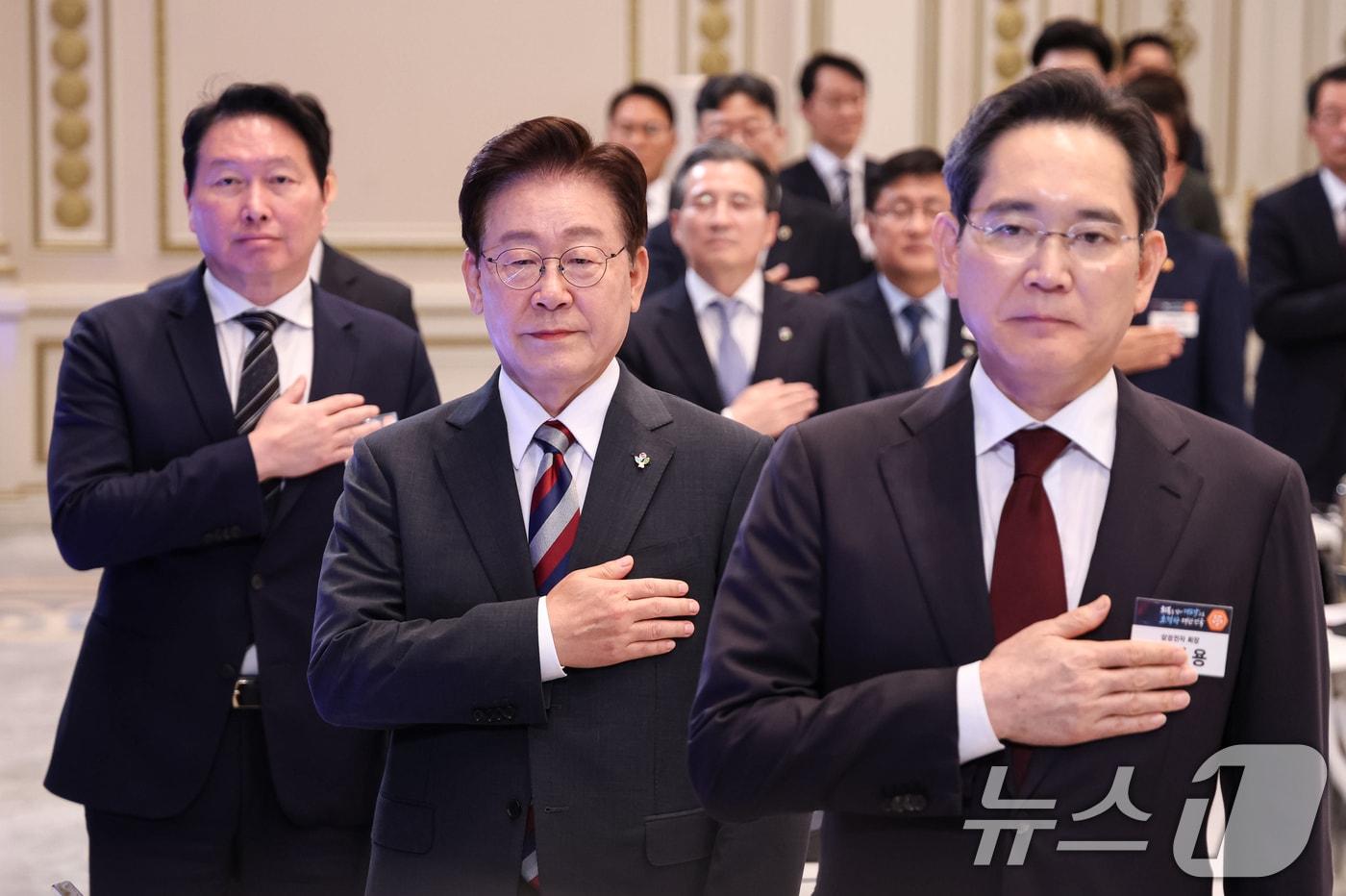 본문 이미지 - 이재명 대통령과 이재용 삼성전자 회장, 최태원 SK그룹 회장이 29일 청와대 영빈관에서 열린 대한민국 대도약 3대 메가프로젝트 국민보고회에서 국민의례를 하고 있다. 2026.6.29 ⓒ 뉴스1 허경 기자