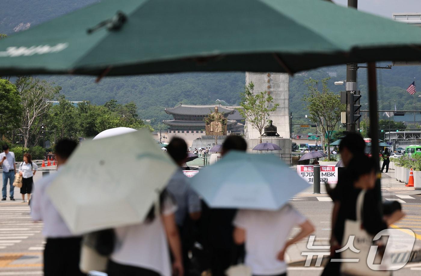 본문 이미지 - 서울 전역에 올해 첫 폭염주의보가 발표된 29일 오후 서울 종로구 광화문 네거리에서 시민들이 횡단보도 그늘막 아래에 모여 햇볕을 피하고 있다. 2026.6.29 ⓒ 뉴스1 오대일 기자