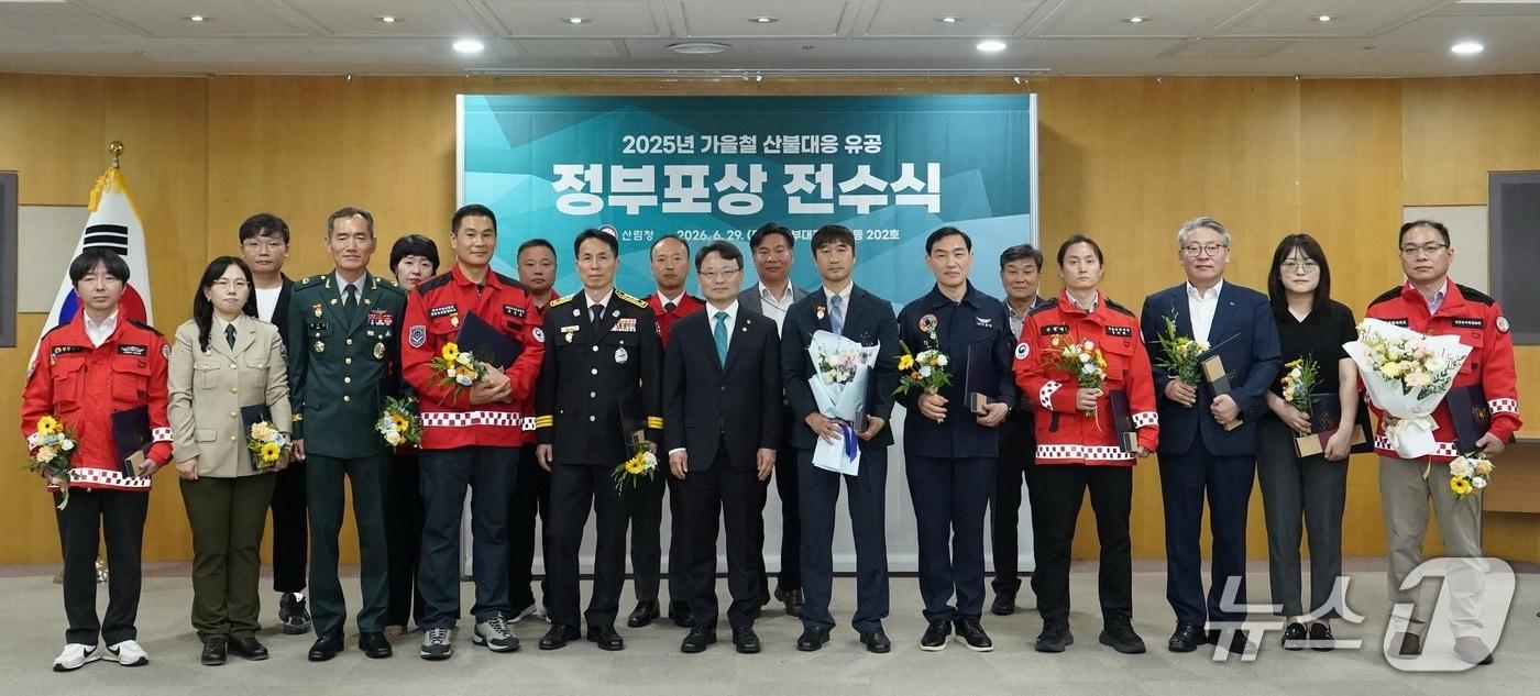 본문 이미지 - 박은식 청장(앞줄 가운데) 29일 정부대전청사에서 열린 “2025년 가을철 산불대응 유공자 정부포상 전수식”에서 수상자들과 기념사진을 촬영하고 있다(산림청 제공.재판매 및 DB금지)/뉴스1