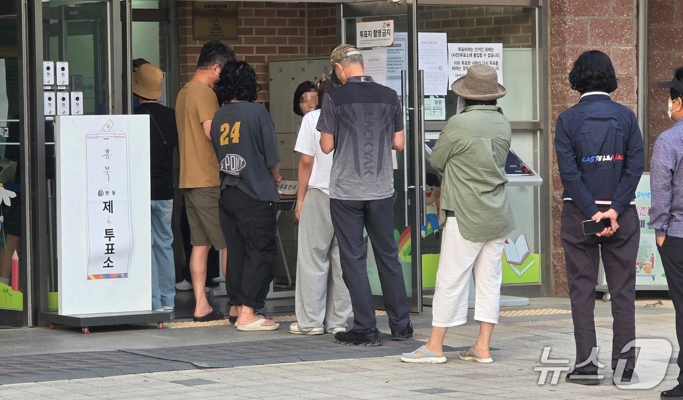 본문 이미지 - 제9회 전국동시지방선거 본투표가 시작된 3일 오전, 충남 홍성 내포초등학교에 마련된 투표소에 유권자들이 줄을 서 있다. 2026.6.3. ⓒ 뉴스1 이시우 기
