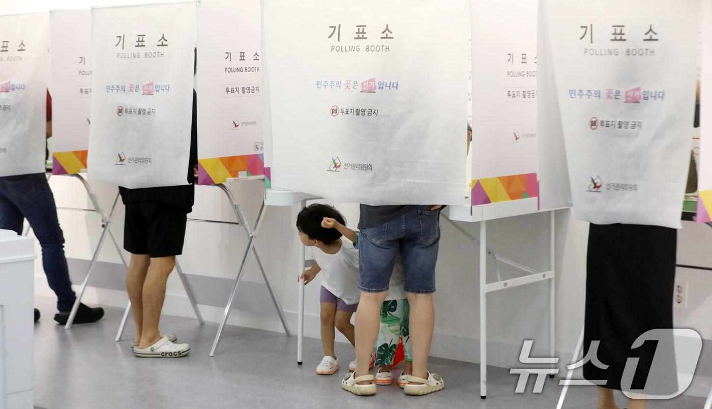 본문 이미지 - 제9회 전국동시지방선거 및 국회의원 재·보궐선거일인 3일 부산 부산진구청에 마련된 부암제1동제4투표소에서 엄마와 투표소를 찾은 아이들이 신기한 듯 바라보고 있다. 2026.6.3 ⓒ 뉴스1 윤일지 기자