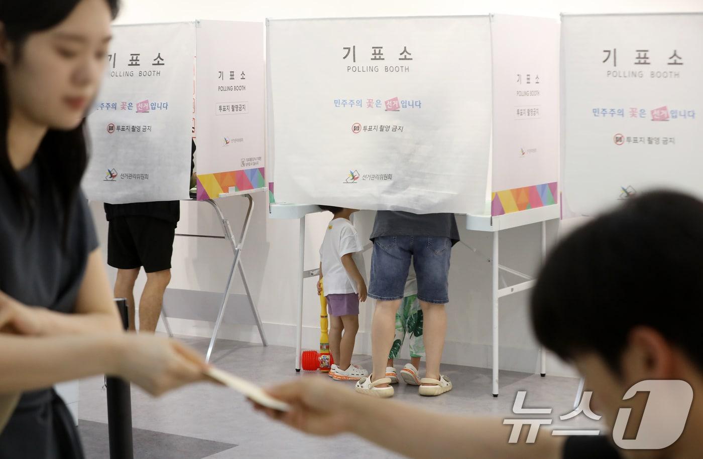 본문 이미지 - 제9회 전국동시지방선거 및 국회의원 재·보궐선거일인 3일 부산 부산진구청에 마련된 부암제1동제4투표소에서 아이들이 엄마가 투표하는 모습을 지켜보고 있다. 2026.6.3 ⓒ 뉴스1 윤일지 기자