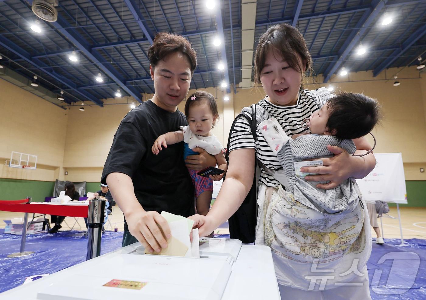 본문 이미지 - 제9회 전국동시지방선거일인 3일 오전 서울 도봉구 도봉동 실내스포츠센터에 마련된 투표소에서 유권자들이 아이들과 함께 투표를 하고 있다. ⓒ 뉴스1 김성진 기자