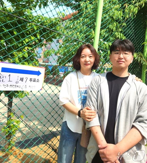 본문 이미지 - 전일고등학교 3학년 최승우 군(오른쪽)이 3일 오전 전주오송초등학교에서 첫 투표를 마친 뒤 어머니 이혜영씨와 함께 기념사진을 촬영하고 있다./뉴스1