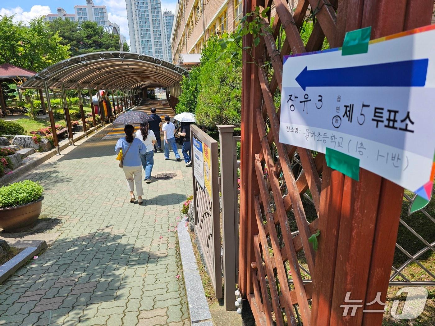 본문 이미지 - 일 김해 율하초등학교에 마련된 장유3동 제5투표소로 양산을 쓴 유권자들이 걸어가고 있다.2026.6.3/뉴스1 박민석기자